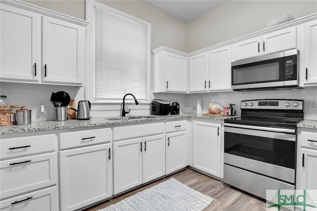 kitchen with white cabinets, stainless steel appliances, and sink