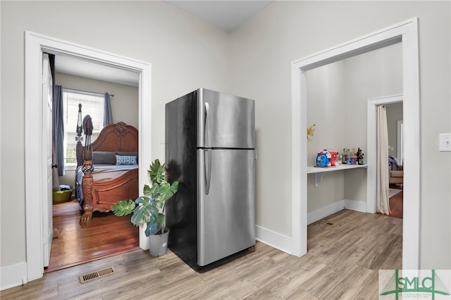 kitchen featuring stainless steel refrigerator and light hardwood / wood-style flooring