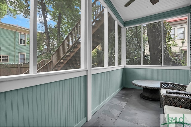 unfurnished sunroom featuring ceiling fan