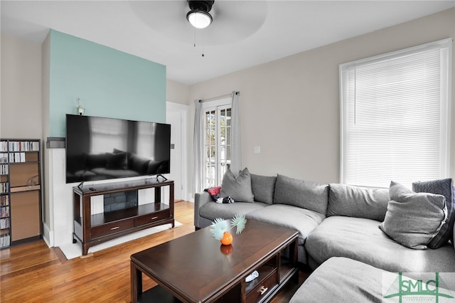 living room featuring ceiling fan, wood-type flooring, and french doors