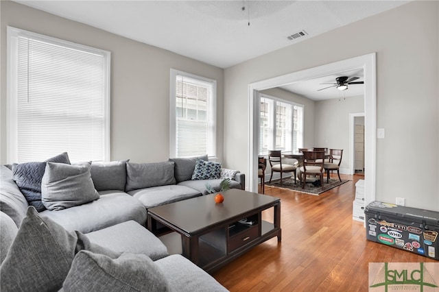 living room with wood-type flooring and ceiling fan