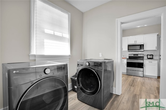 washroom featuring light wood-type flooring and independent washer and dryer