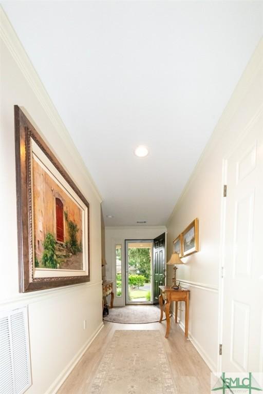 hallway with crown molding and light hardwood / wood-style floors