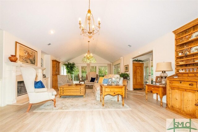 living room featuring lofted ceiling, light hardwood / wood-style flooring, and a chandelier