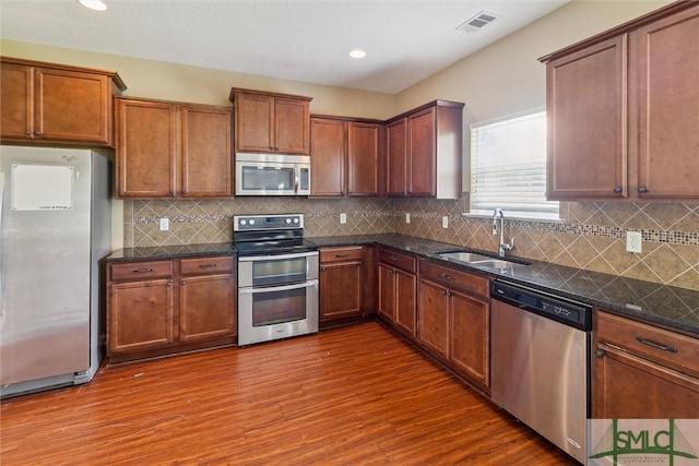 kitchen with sink, stainless steel appliances, dark hardwood / wood-style flooring, and tasteful backsplash