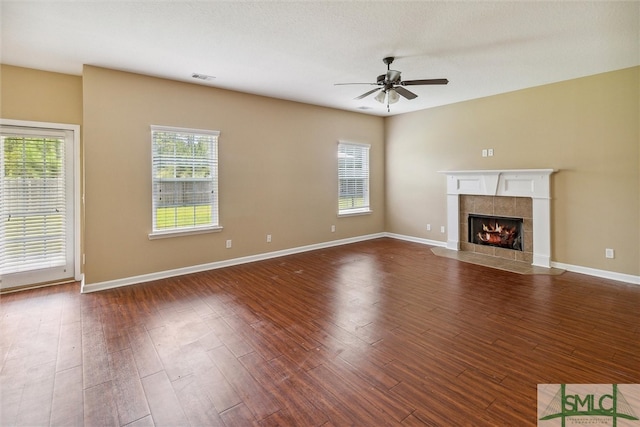 unfurnished living room featuring ceiling fan, a fireplace, and wood-type flooring