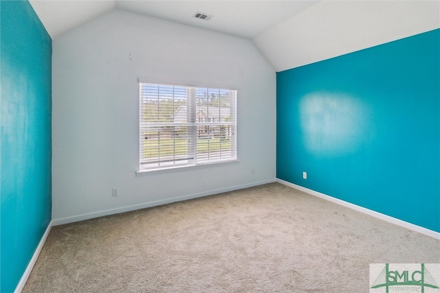 spare room with vaulted ceiling and carpet flooring