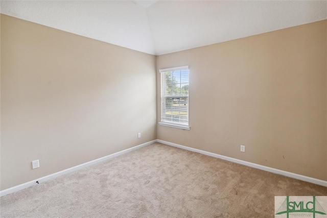 carpeted spare room featuring lofted ceiling