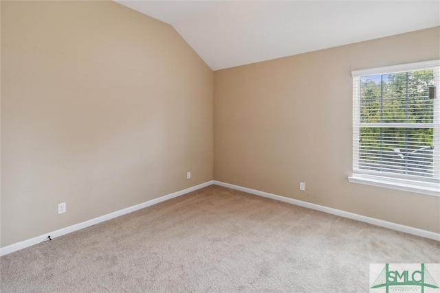 unfurnished room featuring light colored carpet and lofted ceiling