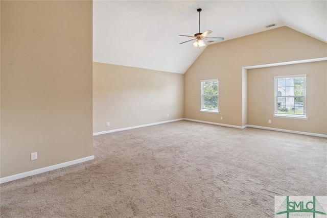 interior space with a wealth of natural light, vaulted ceiling, carpet, and ceiling fan