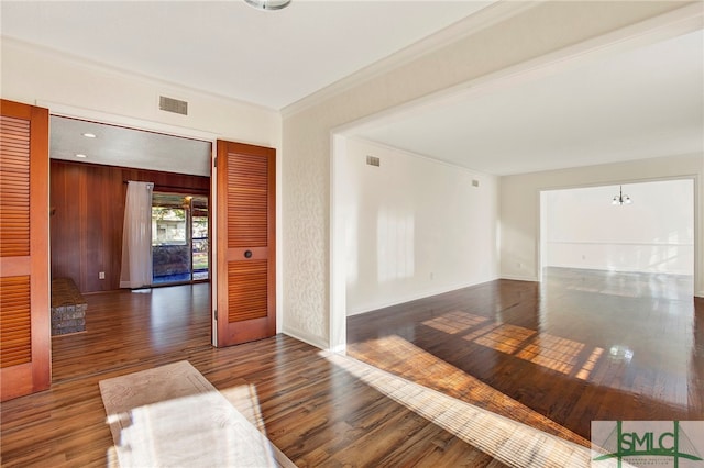 empty room featuring dark wood-type flooring and crown molding