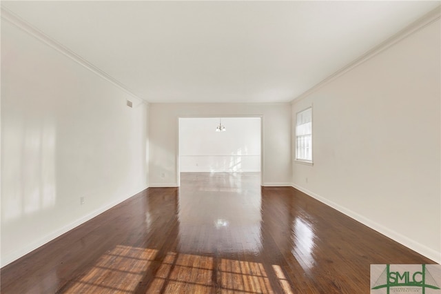 unfurnished room with ornamental molding, a chandelier, and dark hardwood / wood-style flooring