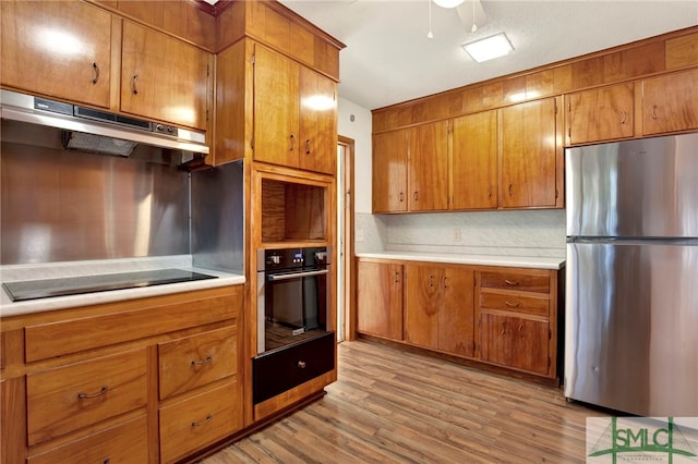 kitchen featuring ceiling fan, tasteful backsplash, black appliances, and light hardwood / wood-style flooring