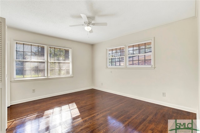 empty room with ceiling fan, a textured ceiling, plenty of natural light, and dark hardwood / wood-style floors