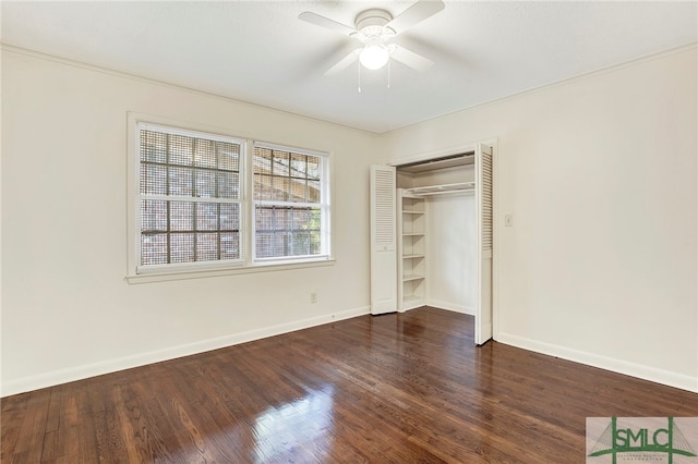 unfurnished bedroom with dark wood-type flooring, ceiling fan, a closet, and crown molding