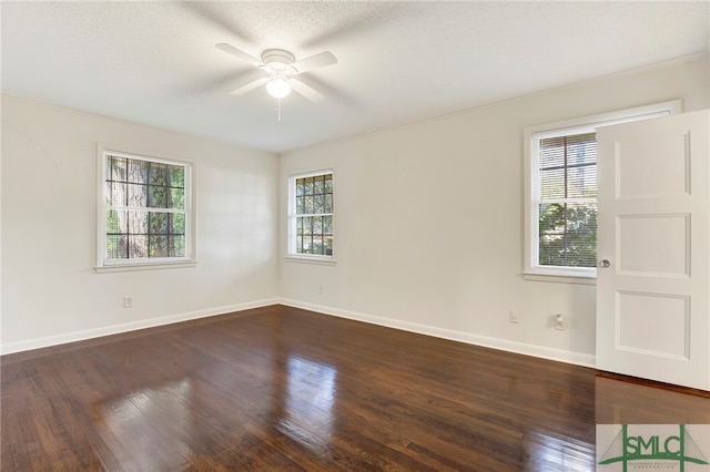 spare room with ceiling fan, a wealth of natural light, and dark hardwood / wood-style flooring