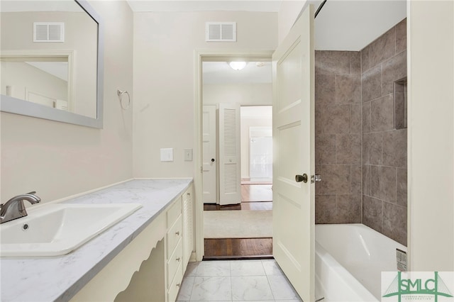 bathroom with vanity and tiled shower / bath combo