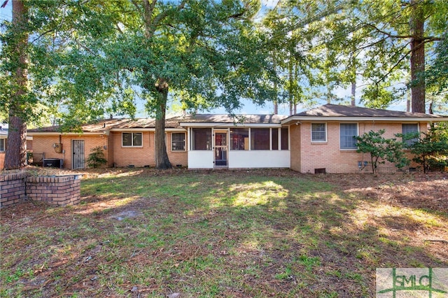 view of front of property featuring a front yard, central air condition unit, and a sunroom