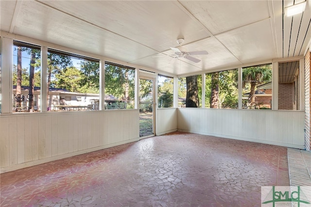 unfurnished sunroom featuring ceiling fan and a wealth of natural light