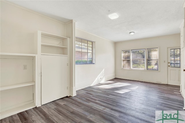 interior space featuring crown molding, a textured ceiling, and dark hardwood / wood-style flooring