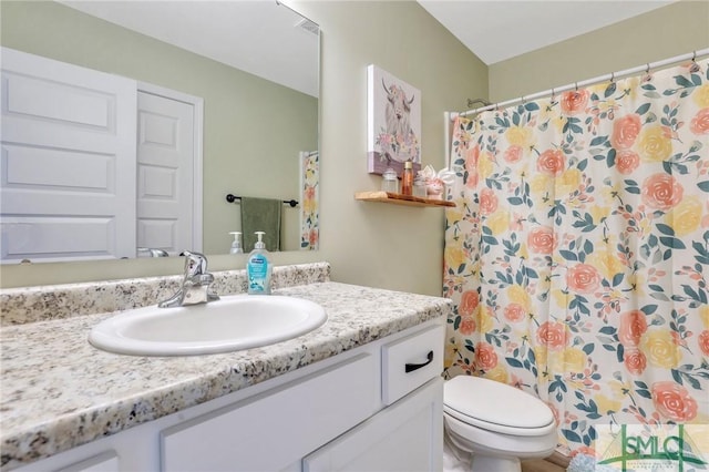 full bath featuring toilet, curtained shower, and vanity