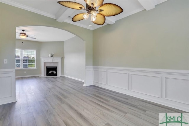 unfurnished living room with light wood-style flooring, ornamental molding, a ceiling fan, and a high end fireplace