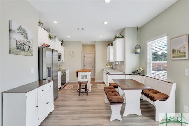 kitchen featuring appliances with stainless steel finishes, light wood-type flooring, white cabinets, and recessed lighting