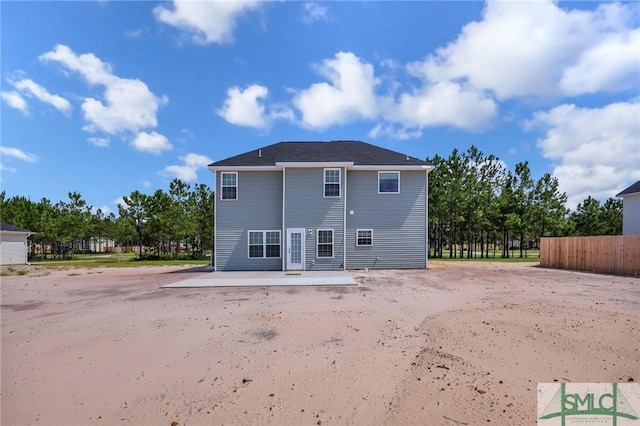 rear view of house featuring a patio and fence