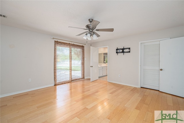 unfurnished room with ceiling fan, light hardwood / wood-style flooring, and a textured ceiling