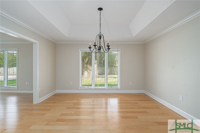 unfurnished dining area with a raised ceiling, plenty of natural light, a chandelier, and light hardwood / wood-style floors