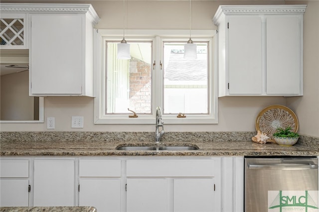 kitchen featuring sink, white cabinetry, hanging light fixtures, light stone countertops, and stainless steel dishwasher