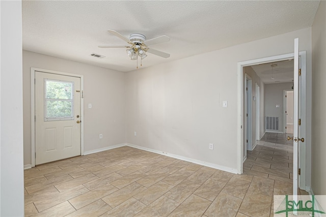 empty room featuring a textured ceiling and ceiling fan