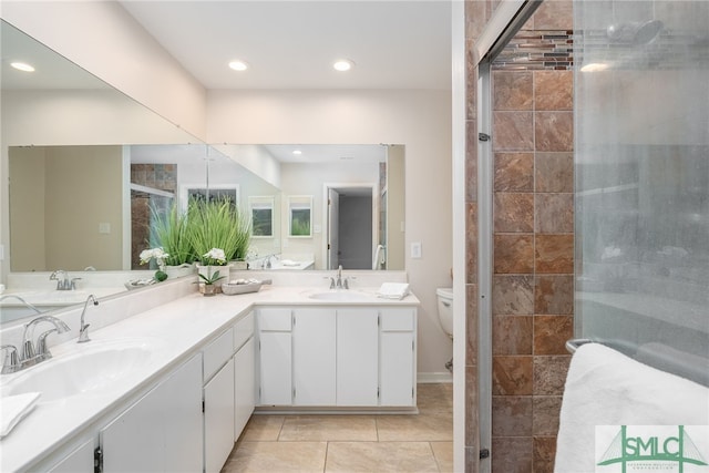 bathroom with an enclosed shower, vanity, tile patterned floors, and toilet