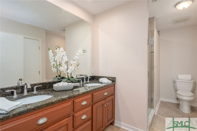 bathroom featuring vanity, toilet, and a shower with shower door