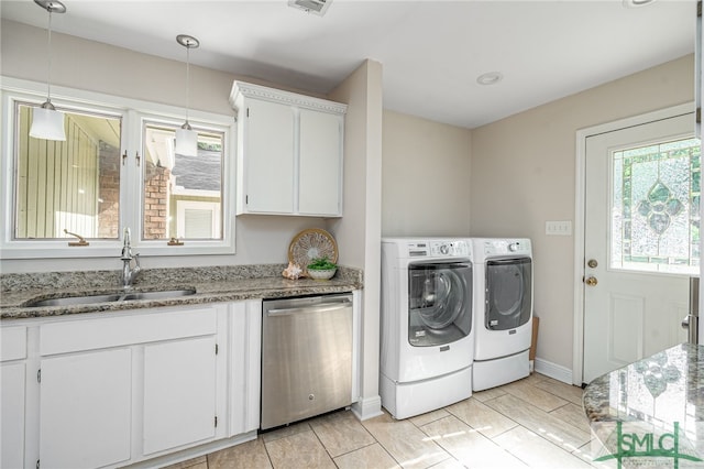 clothes washing area featuring sink and washer and clothes dryer