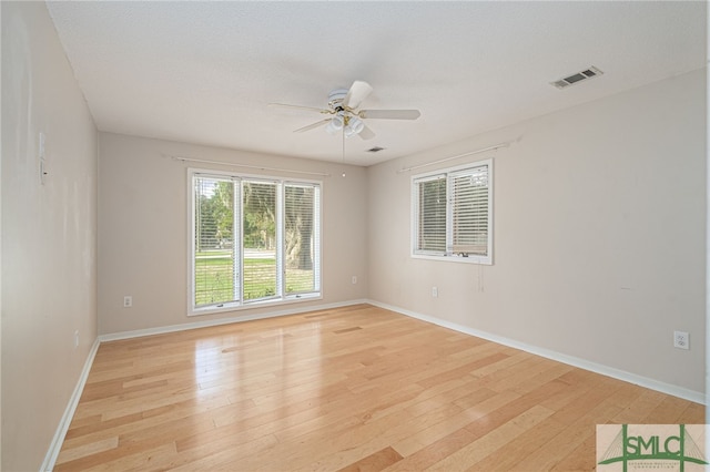 unfurnished room featuring ceiling fan, a textured ceiling, and light wood-type flooring