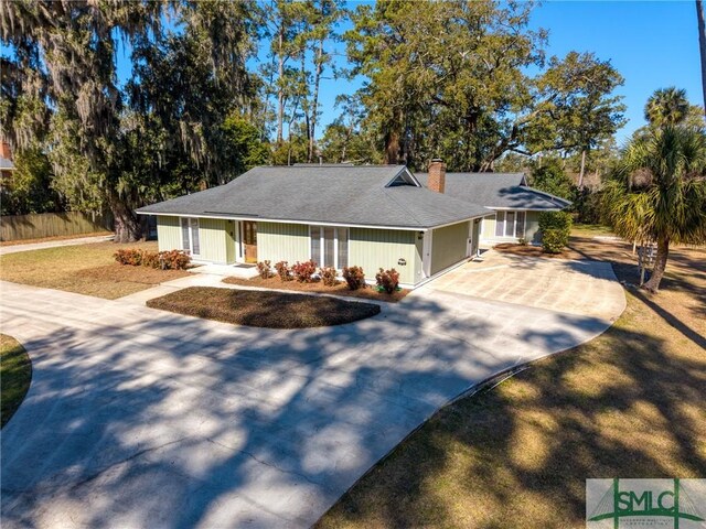 ranch-style home featuring a garage and a front lawn