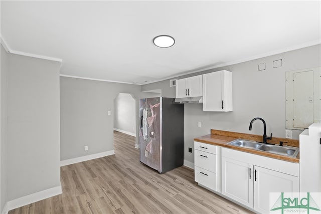 kitchen with sink, white cabinetry, light hardwood / wood-style floors, and ornamental molding