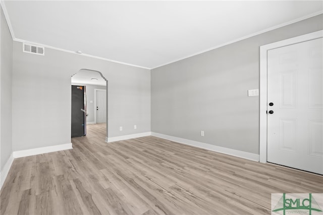 empty room with light hardwood / wood-style floors and ornamental molding