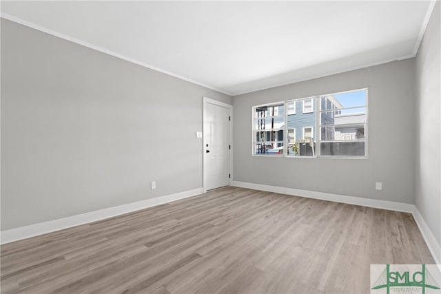 empty room featuring ornamental molding and light wood-type flooring