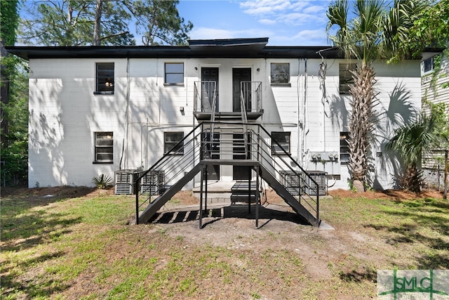 back of house with central AC and a yard