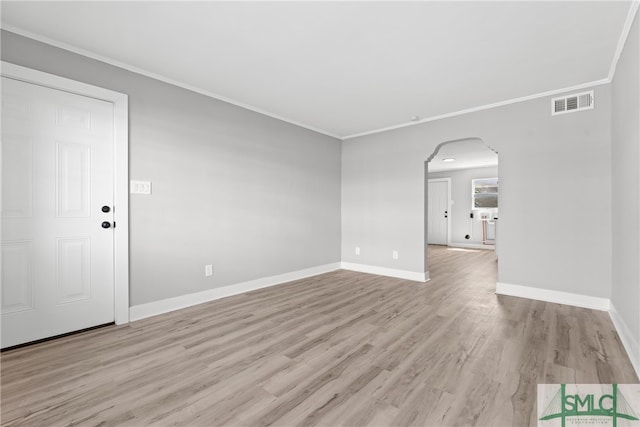 empty room featuring ornamental molding and light wood-type flooring