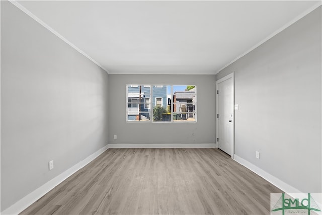 empty room featuring light hardwood / wood-style floors and crown molding