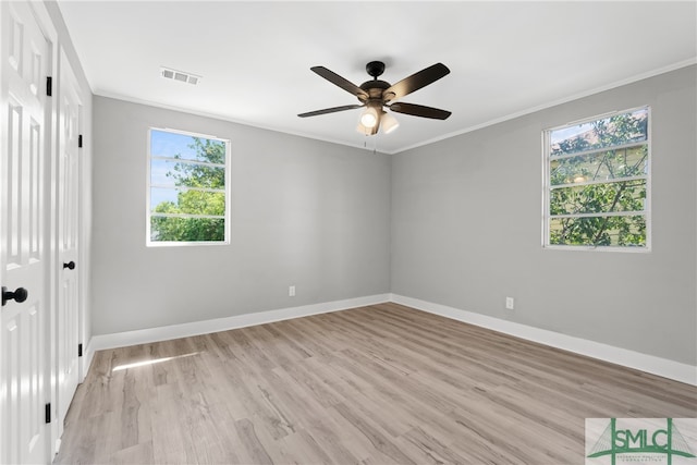 empty room with a wealth of natural light, ceiling fan, crown molding, and light wood-type flooring