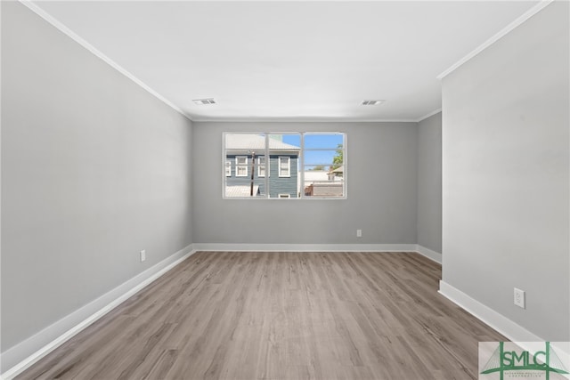 spare room with light wood-type flooring and ornamental molding