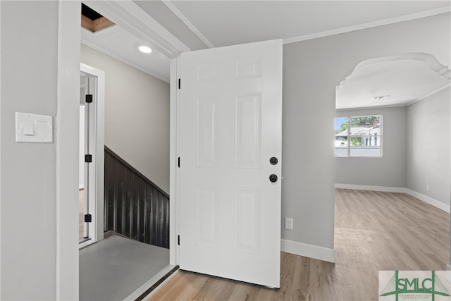 entrance foyer with light hardwood / wood-style flooring and crown molding