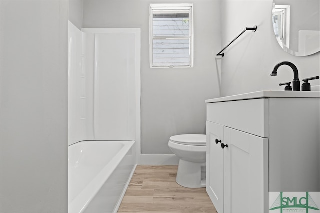 bathroom with toilet, hardwood / wood-style flooring, and vanity