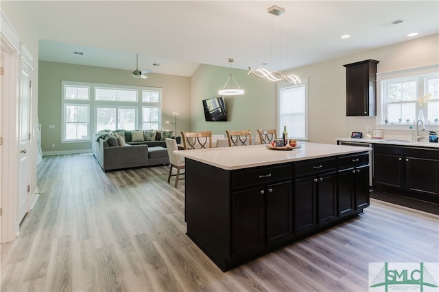 kitchen featuring sink, plenty of natural light, light hardwood / wood-style floors, and a kitchen island