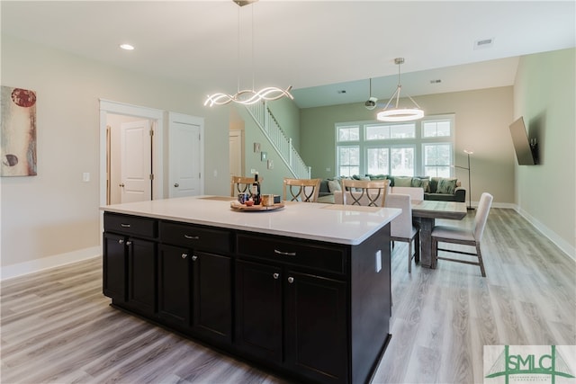 kitchen with a center island, hanging light fixtures, light hardwood / wood-style flooring, and a notable chandelier