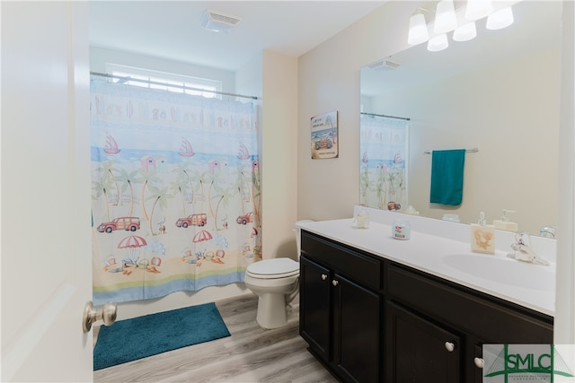 bathroom featuring toilet, walk in shower, vanity, and wood-type flooring